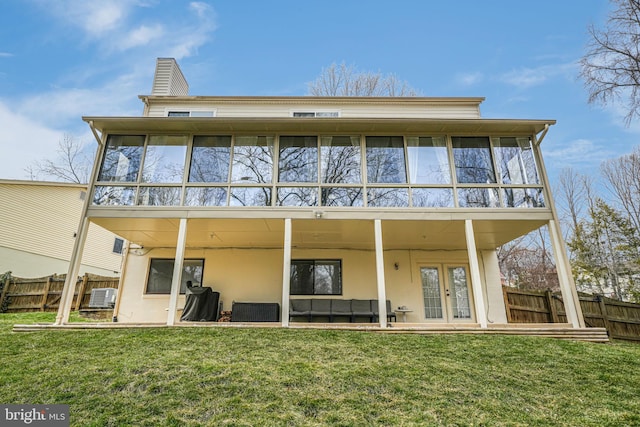 back of house featuring a lawn, french doors, and fence