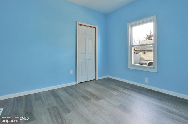 empty room with wood finished floors and baseboards