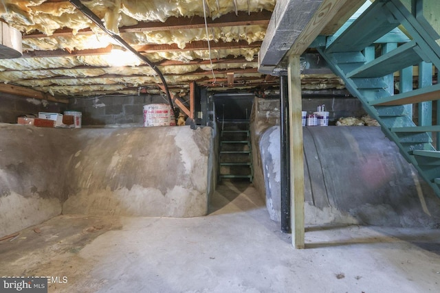 unfinished basement featuring stairway and heating fuel