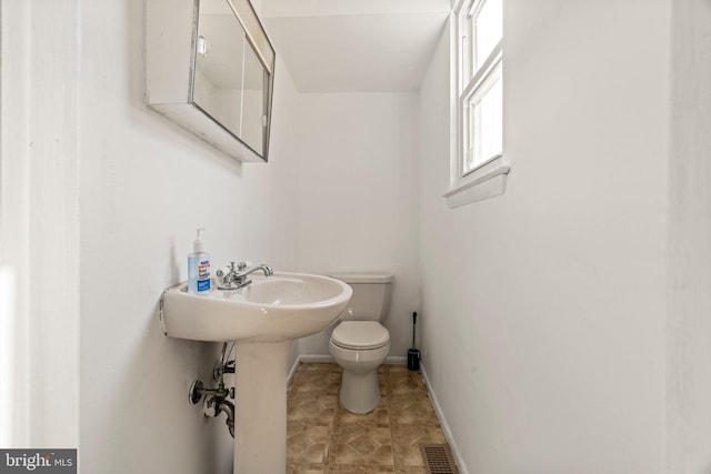 bathroom featuring toilet, baseboards, and visible vents