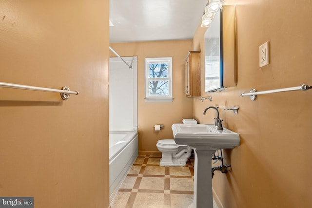 full bath with baseboards, toilet, tile patterned floors, shower / washtub combination, and a sink