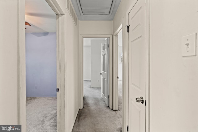 hallway with visible vents and carpet flooring