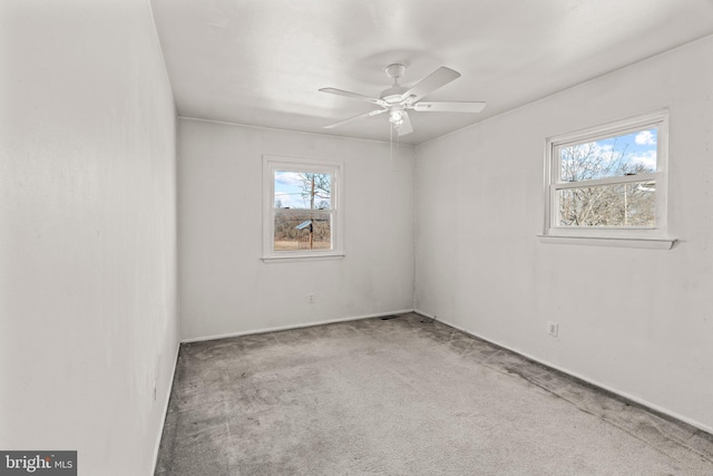 carpeted empty room featuring plenty of natural light and a ceiling fan