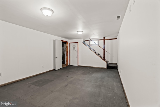 below grade area with stairs, visible vents, and baseboards