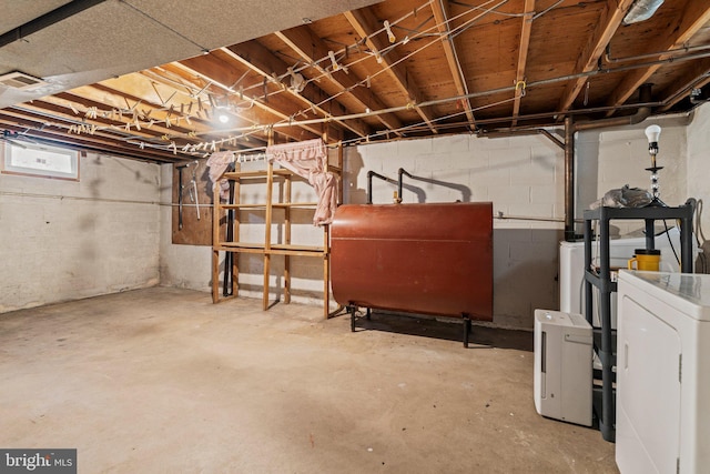 basement featuring heating fuel, visible vents, and washer / clothes dryer