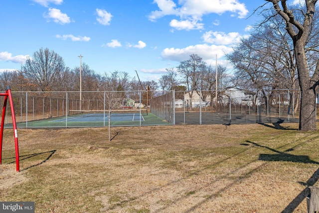 view of sport court featuring a lawn and fence