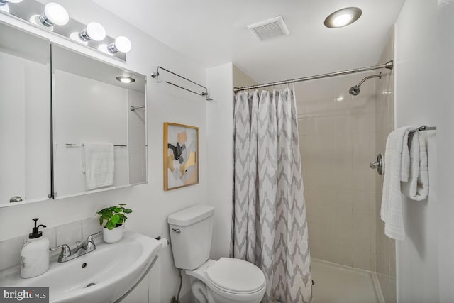 full bath with toilet, tiled shower, a sink, and visible vents