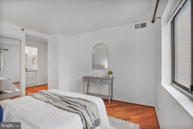 bedroom with visible vents and wood finished floors