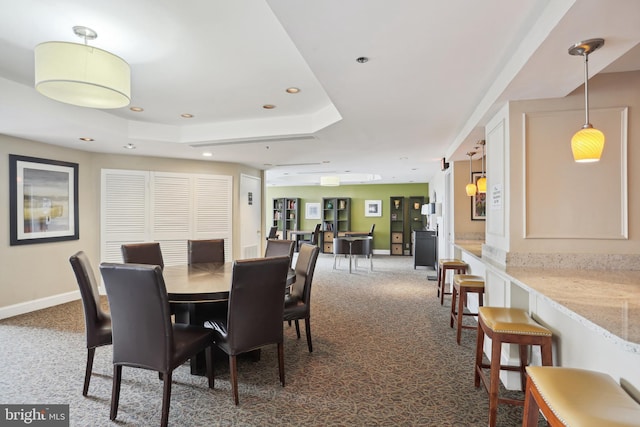 dining space with baseboards, dark colored carpet, a raised ceiling, and recessed lighting