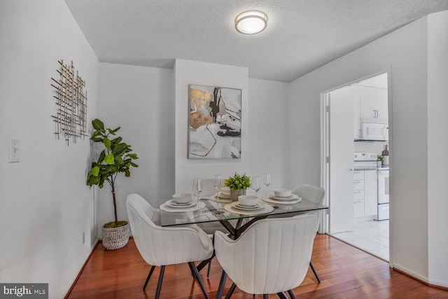 dining room featuring a textured ceiling and light wood-style flooring