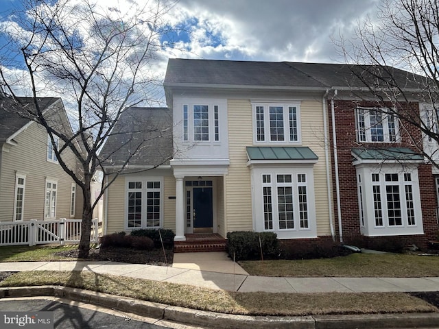 view of front of home featuring brick siding and fence