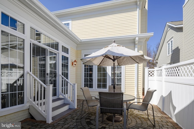 view of patio featuring entry steps, fence, and outdoor dining space