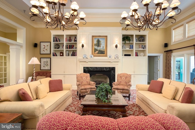 living area with decorative columns, a fireplace, ornamental molding, and a notable chandelier