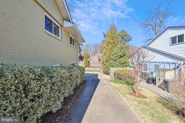 view of side of property featuring fence and brick siding