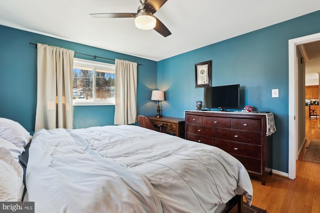 bedroom featuring a ceiling fan, baseboards, and light wood finished floors