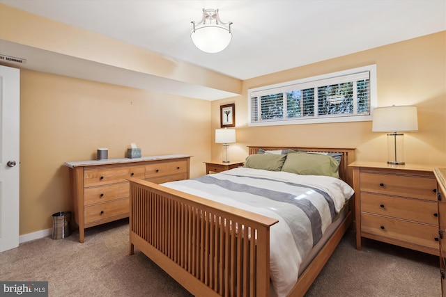 bedroom with baseboards, visible vents, and light colored carpet