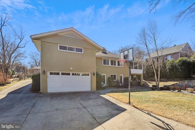 view of front of home featuring a garage, concrete driveway, a front lawn, and stucco siding