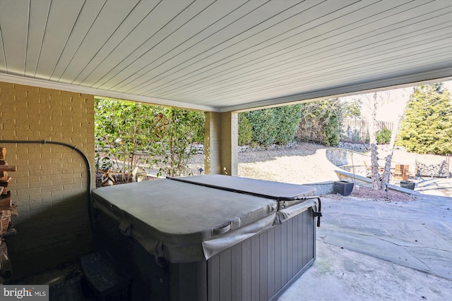 view of patio / terrace featuring fence and a hot tub