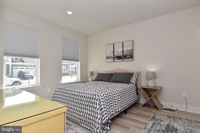 bedroom with light wood finished floors, baseboards, and recessed lighting