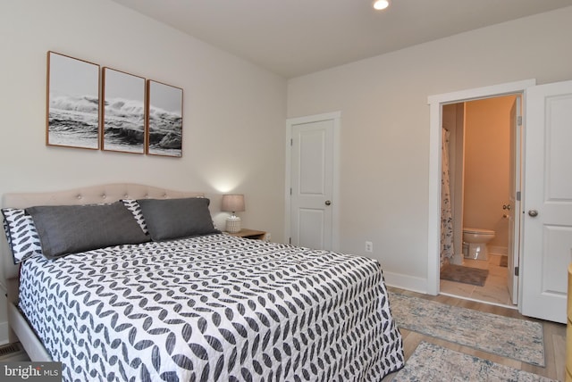 bedroom with recessed lighting, connected bathroom, baseboards, and wood finished floors