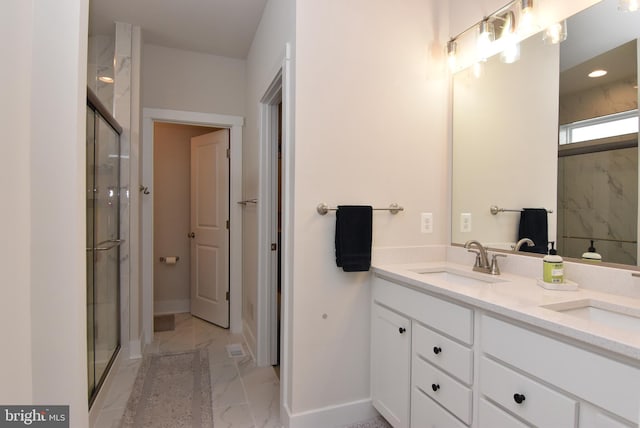 full bathroom with marble finish floor, a sink, and a stall shower