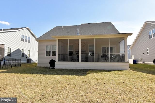 back of property featuring a yard, roof with shingles, and a sunroom