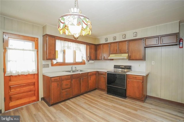 kitchen with range with electric cooktop, light countertops, a sink, and under cabinet range hood