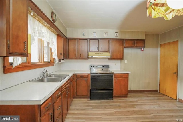 kitchen with brown cabinets, light countertops, stainless steel range with electric cooktop, and under cabinet range hood