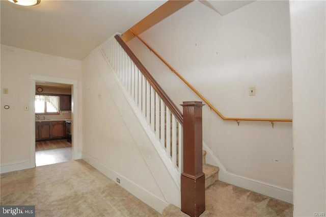 stairs featuring carpet floors and baseboards