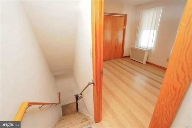 stairs with radiator heating unit and wood finished floors