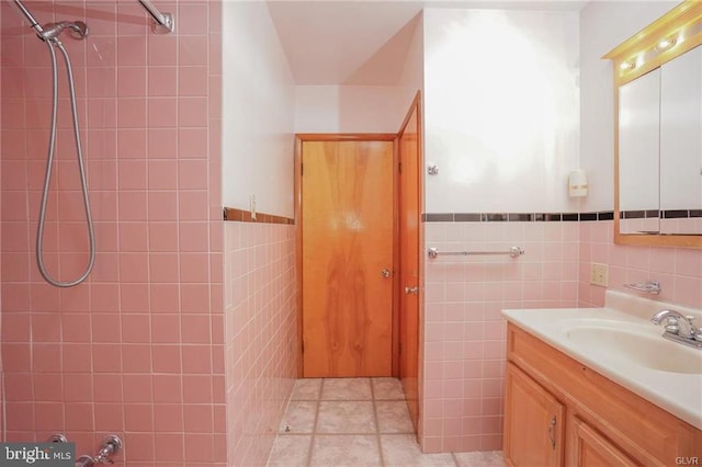 full bathroom featuring tile patterned flooring, a shower, tile walls, and vanity