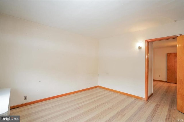 unfurnished room featuring light wood finished floors and baseboards