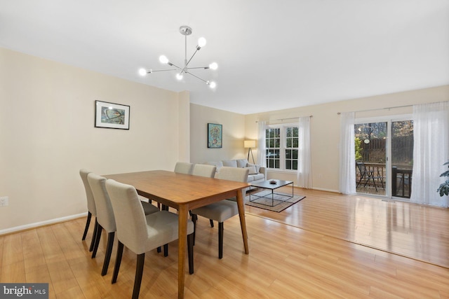 dining room with light wood-style floors, baseboards, and a chandelier