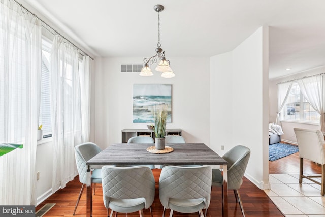 dining room with visible vents, baseboards, and wood finished floors