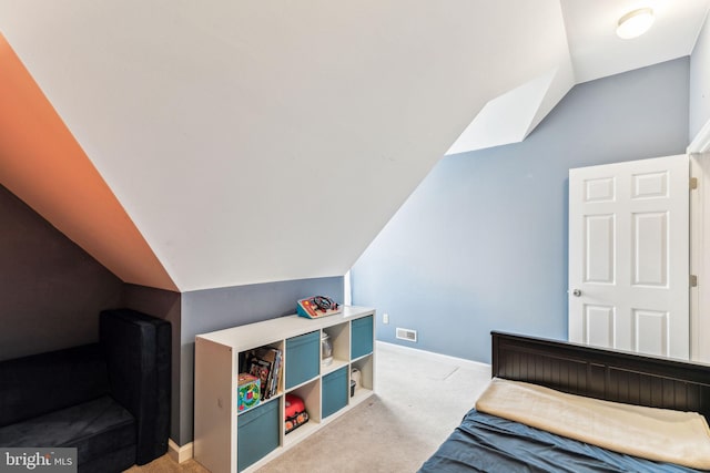 bedroom with baseboards, vaulted ceiling, and light colored carpet