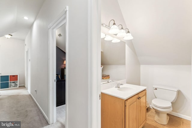 half bath with baseboards, vaulted ceiling, vanity, and toilet