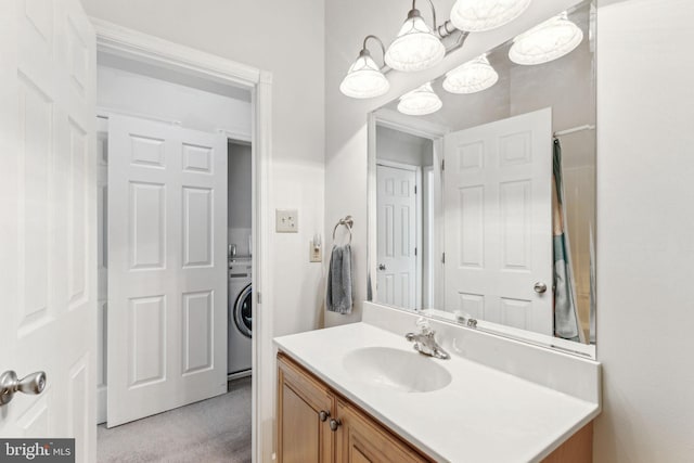 bathroom with washer / clothes dryer, a notable chandelier, and vanity