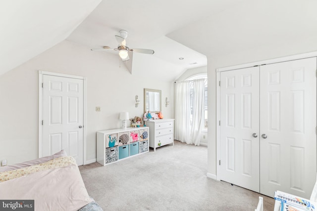 bedroom featuring ceiling fan, light colored carpet, baseboards, vaulted ceiling, and a closet