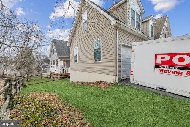 view of property exterior featuring a garage, a lawn, and fence