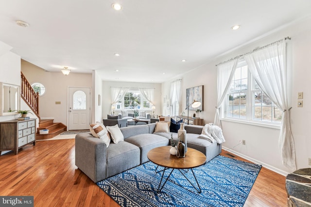 living area featuring light wood-style flooring, recessed lighting, stairway, and baseboards