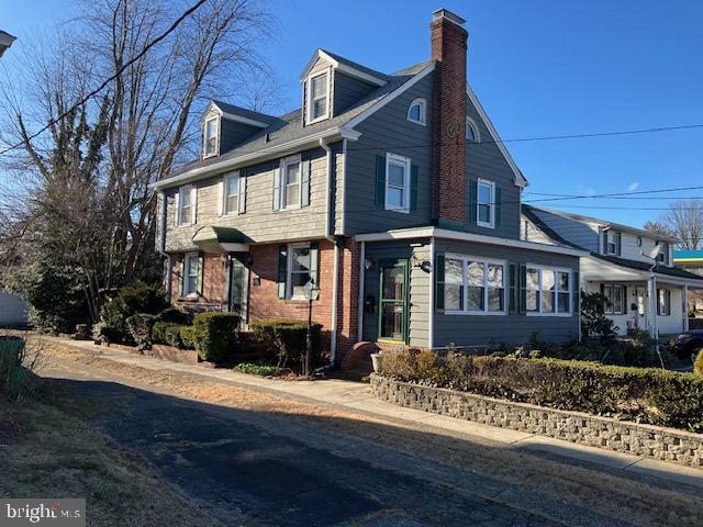 view of front of house with a chimney and brick siding