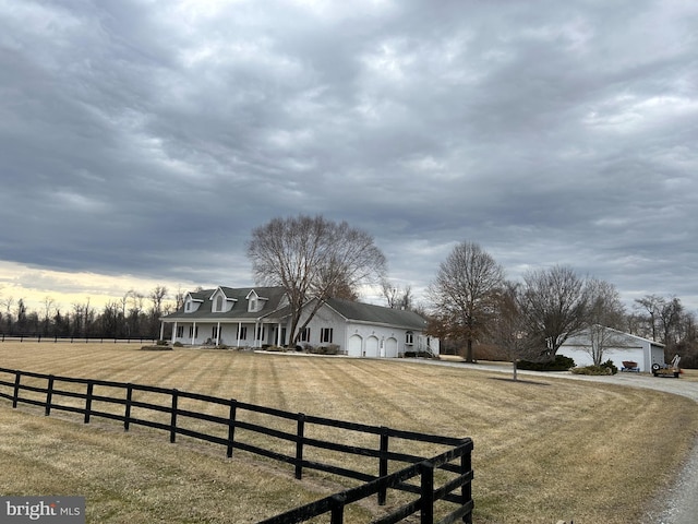 exterior space with a garage, covered porch, a fenced front yard, and a front yard