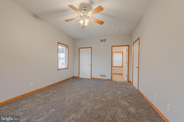 unfurnished bedroom with baseboards, visible vents, carpet flooring, and ensuite bathroom