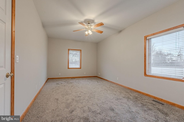 unfurnished room with carpet, visible vents, and baseboards