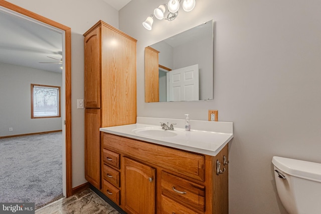 bathroom with toilet, baseboards, a ceiling fan, and vanity