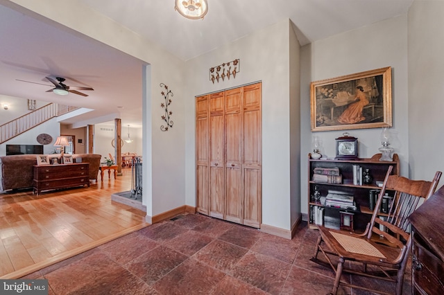 entryway with ceiling fan, baseboards, and stairs