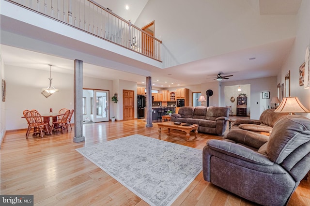 living area with ceiling fan, a wood stove, light wood-style flooring, and recessed lighting