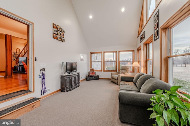 living room with high vaulted ceiling, carpet floors, a wealth of natural light, and baseboards