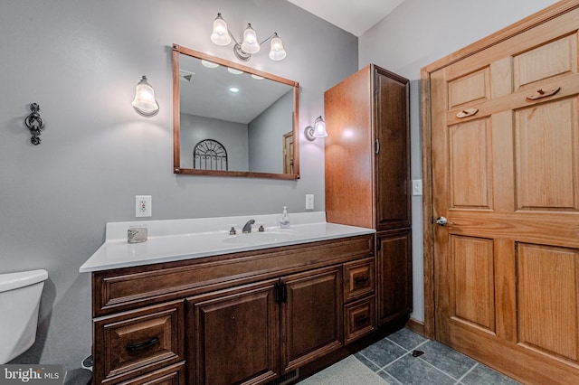 bathroom with toilet, tile patterned floors, and vanity