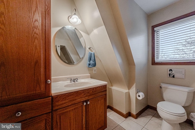 bathroom with tile patterned flooring, baseboards, vanity, and toilet